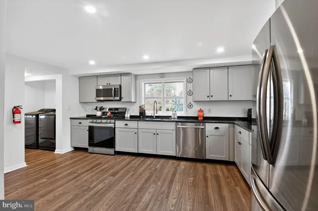 a kitchen with stainless steel appliances granite countertop a refrigerator and a stove top oven
