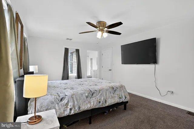 a bedroom with a bed tv and a table