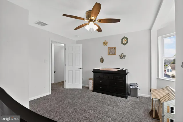 a living room with furniture and a ceiling fan
