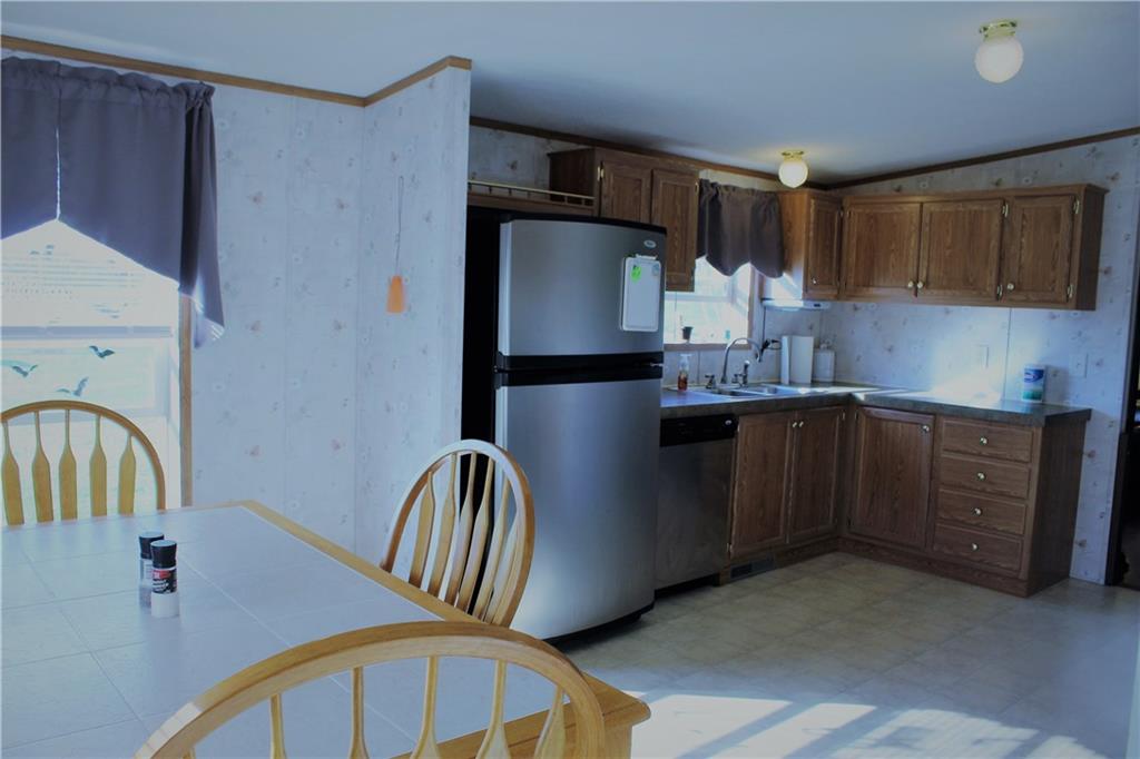 349 Country Lane Road Prospect, PA 16052 - Photo 4 of 25 a kitchen with stainless steel appliances granite countertop a refrigerator a sink a stove and countertops with wooden floor