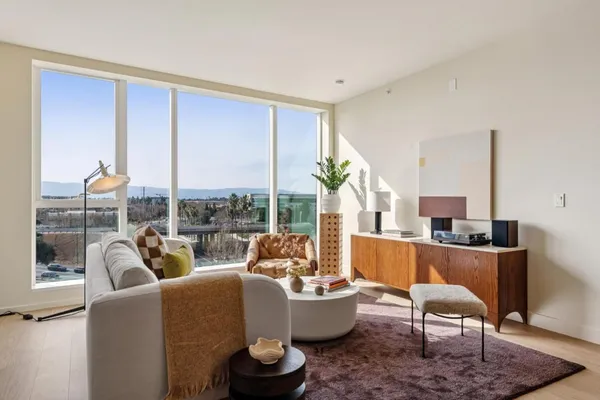 a kitchen with stainless steel appliances a dining table chairs refrigerator and microwave