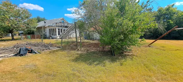 a view of a yard with yellow house