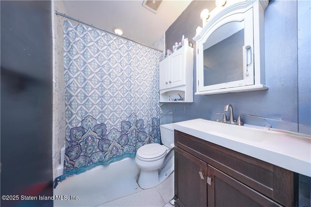 20 Buel Avenue, Unit A Staten Island, NY 10304 - Photo 15 of 30 a bathroom with a sink a toilet and mirror