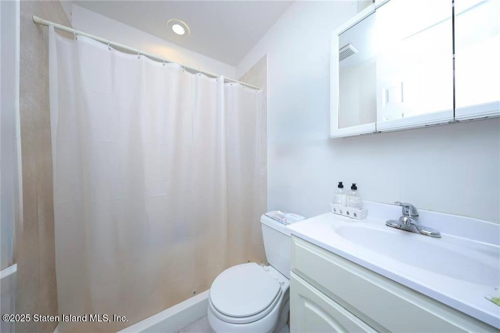 20 Buel Avenue, Unit A Staten Island, NY 10304 - Photo 20 of 30 a bathroom with a sink a toilet and a mirror