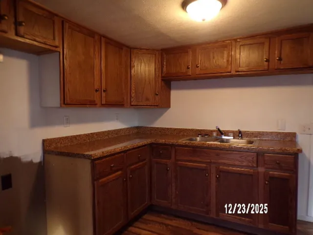 a kitchen with granite countertop a sink and cabinets