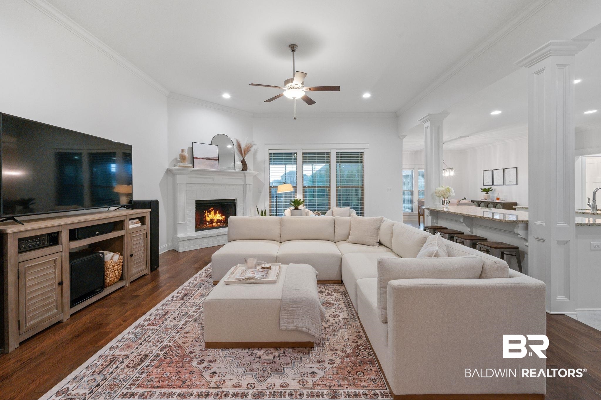 418 Fortune Drive Fairhope, AL 36532 - Photo 6 of 63 Living room featuring ornamental molding, decorative columns, ceiling fan, and dark hardwood / wood-style floors