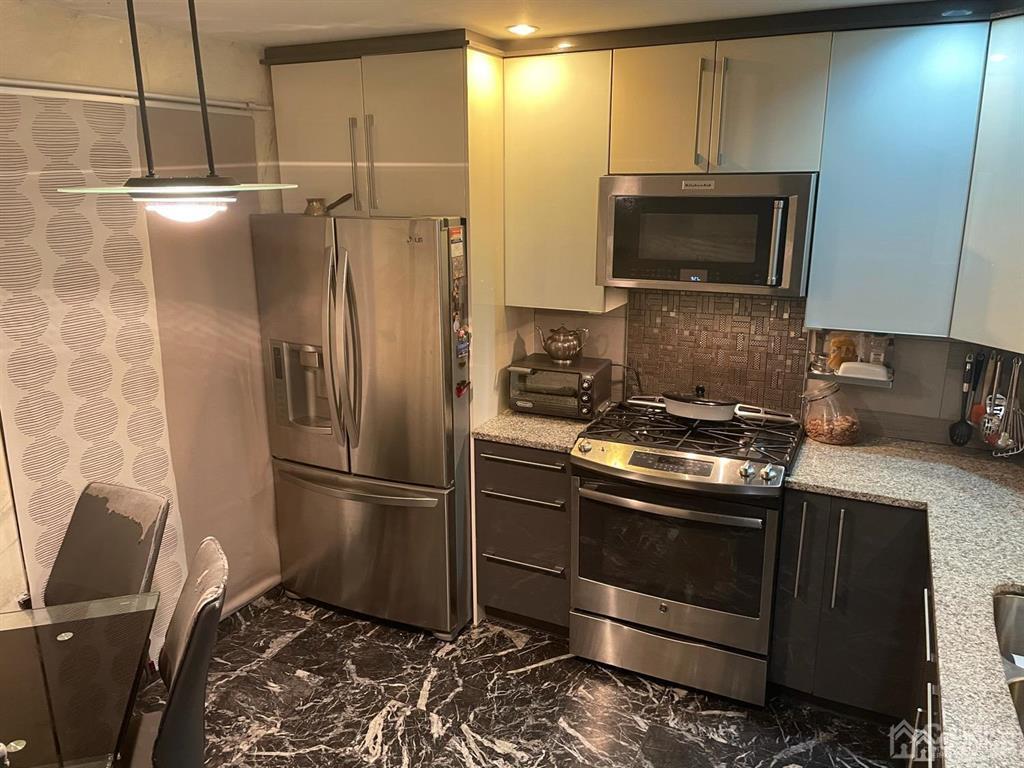a metallic refrigerator freezer sitting in a kitchen