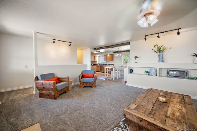 a living room with furniture and kitchen view