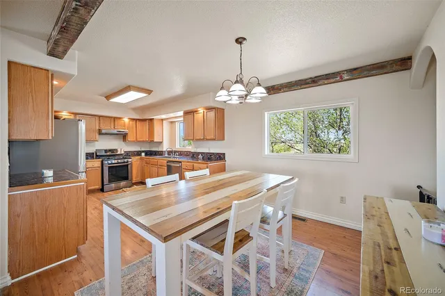 a kitchen with stainless steel appliances granite countertop a stove refrigerator and wooden floor