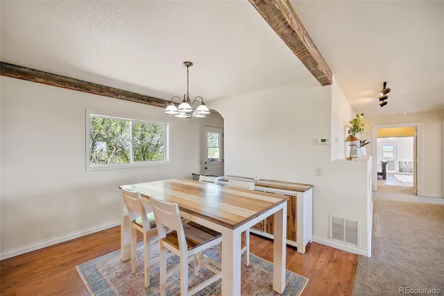 a view of a dining room with furniture wooden floor and chandelier