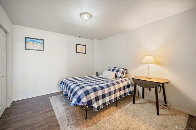 a bedroom with a bed lamp and a table