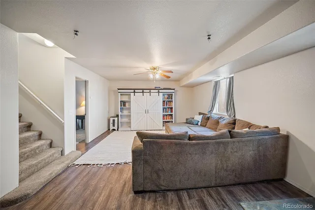 a living room with furniture and a wooden floor