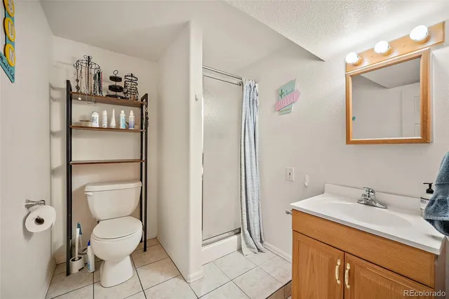 a bathroom with a toilet sink vanity and mirror