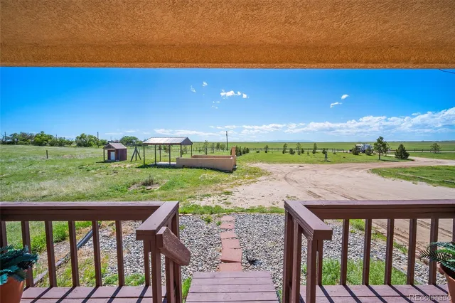 a view of yard from deck with patio