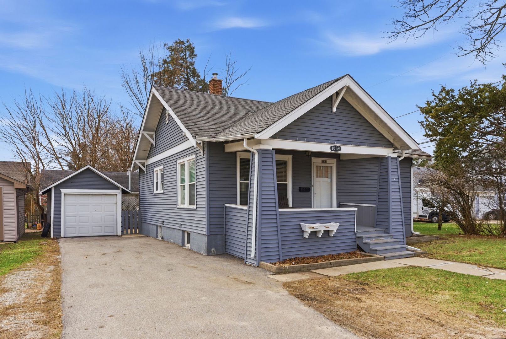 1059 Larkin Avenue Elgin, IL 60123 - Photo 2 of 25 a front view of a house with a garden and trees