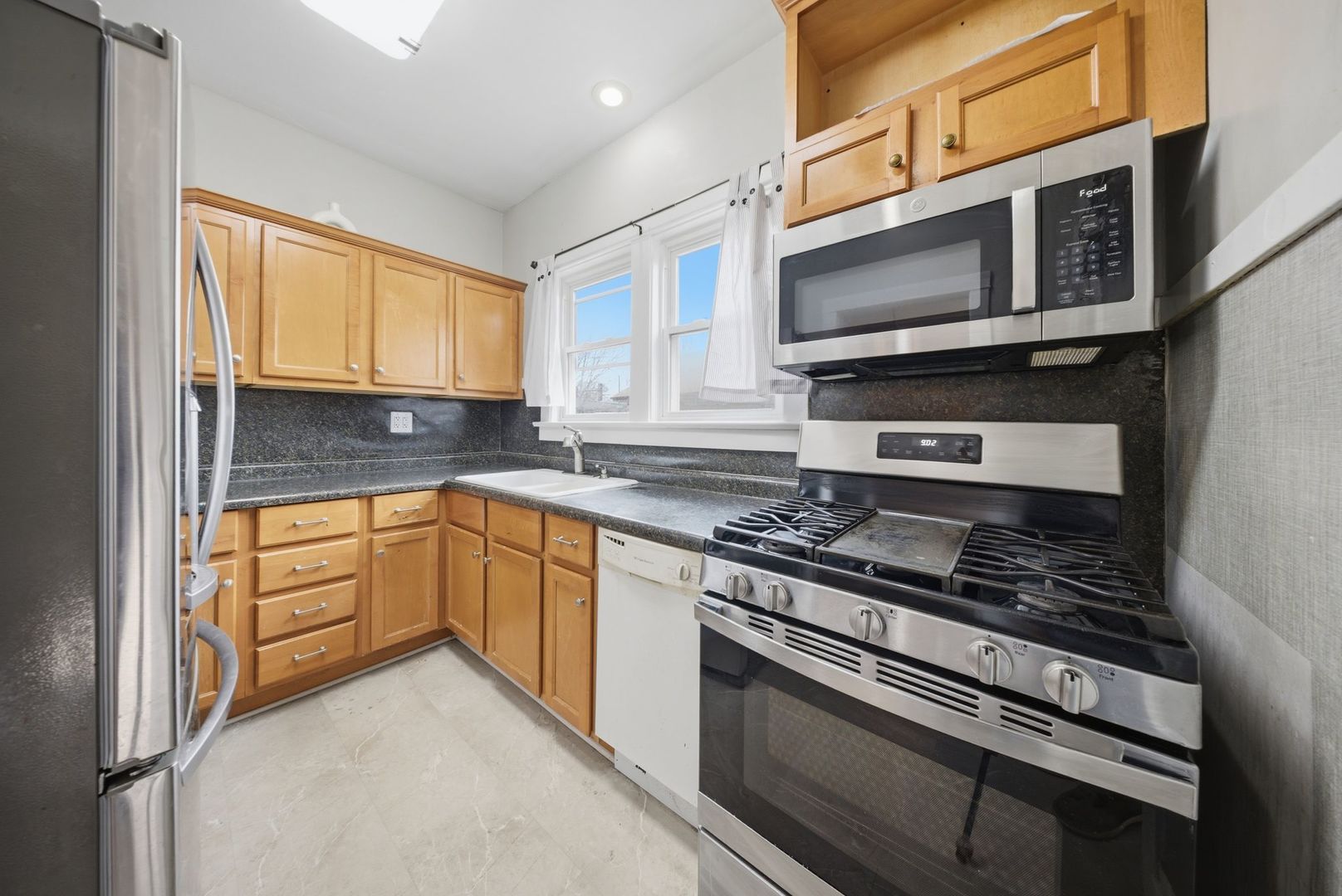 1059 Larkin Avenue Elgin, IL 60123 - Photo 7 of 25 a kitchen with stainless steel appliances a sink stove and microwave