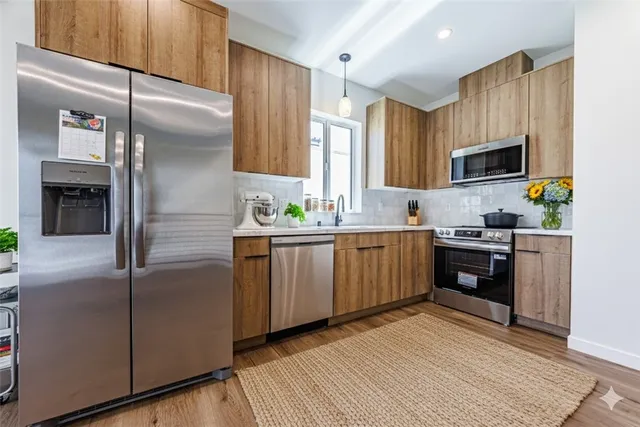 a kitchen with stainless steel appliances a refrigerator sink and microwave