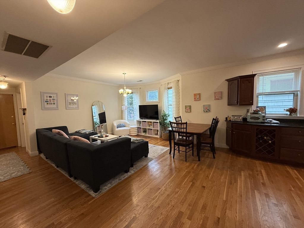 106 Chester Street, Unit 2 Boston, MA 02134 - Photo 2 of 9 a living room with furniture kitchen view and a wooden floor