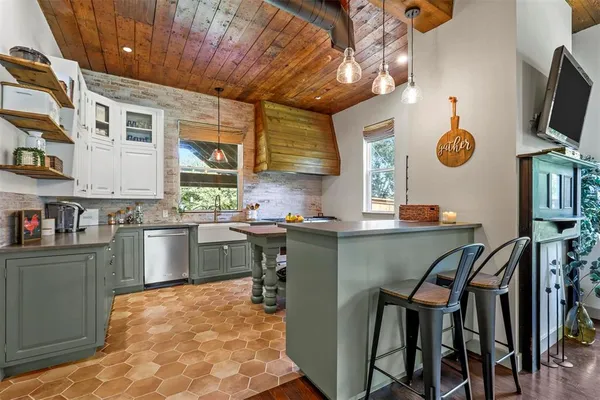 a kitchen with a stove a sink a window and cabinets