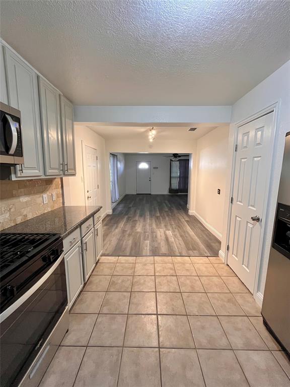 1324 Maple Drive Garland, TX 75040 - Photo 4 of 10 a kitchen with a sink a stove and cabinets