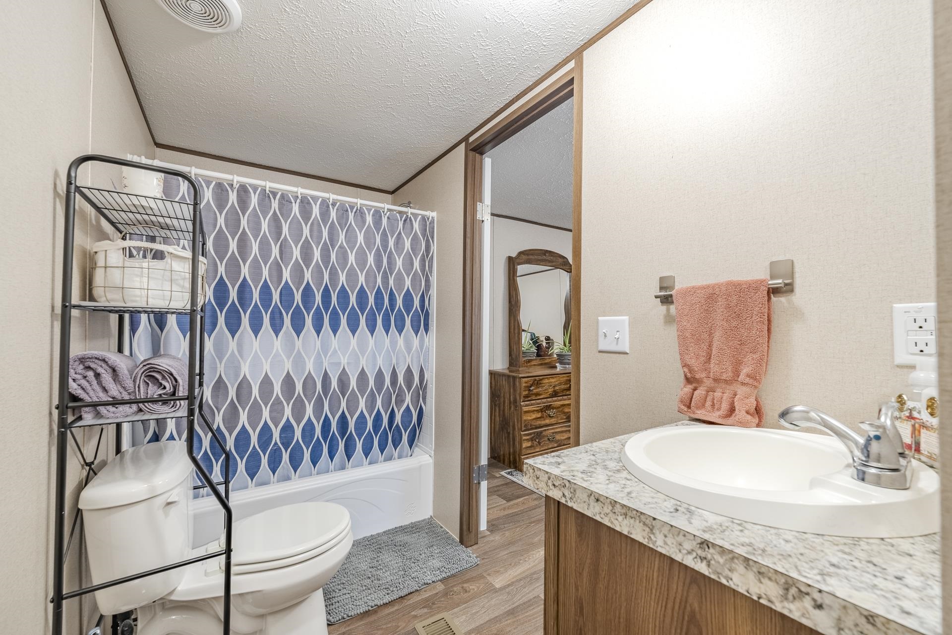 3275 Glendale Road Adamsville, TN 38310 - Photo 22 of 39 a bathroom with a granite countertop sink a mirror and shower