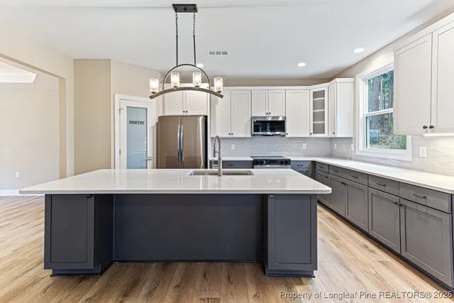a kitchen with kitchen island a sink stainless steel appliances and cabinets