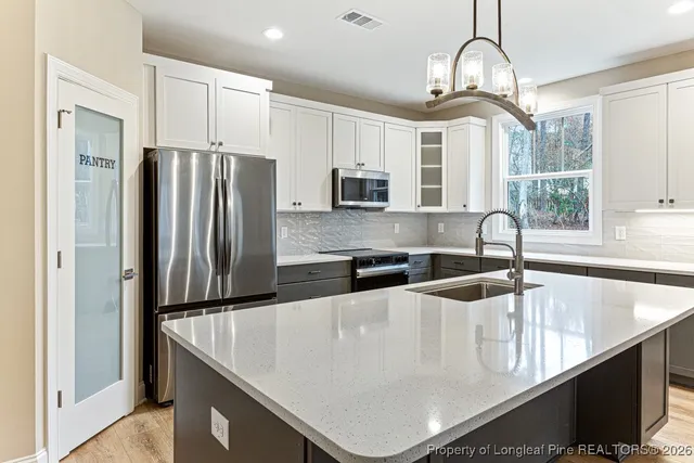 a kitchen with stainless steel appliances granite countertop a sink a stove and a refrigerator
