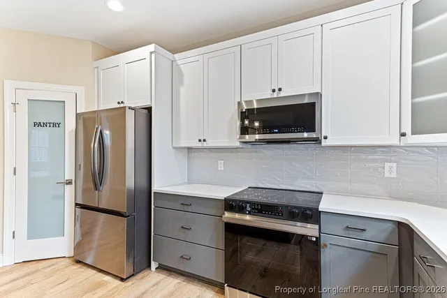 a kitchen with stainless steel appliances white cabinets and a refrigerator