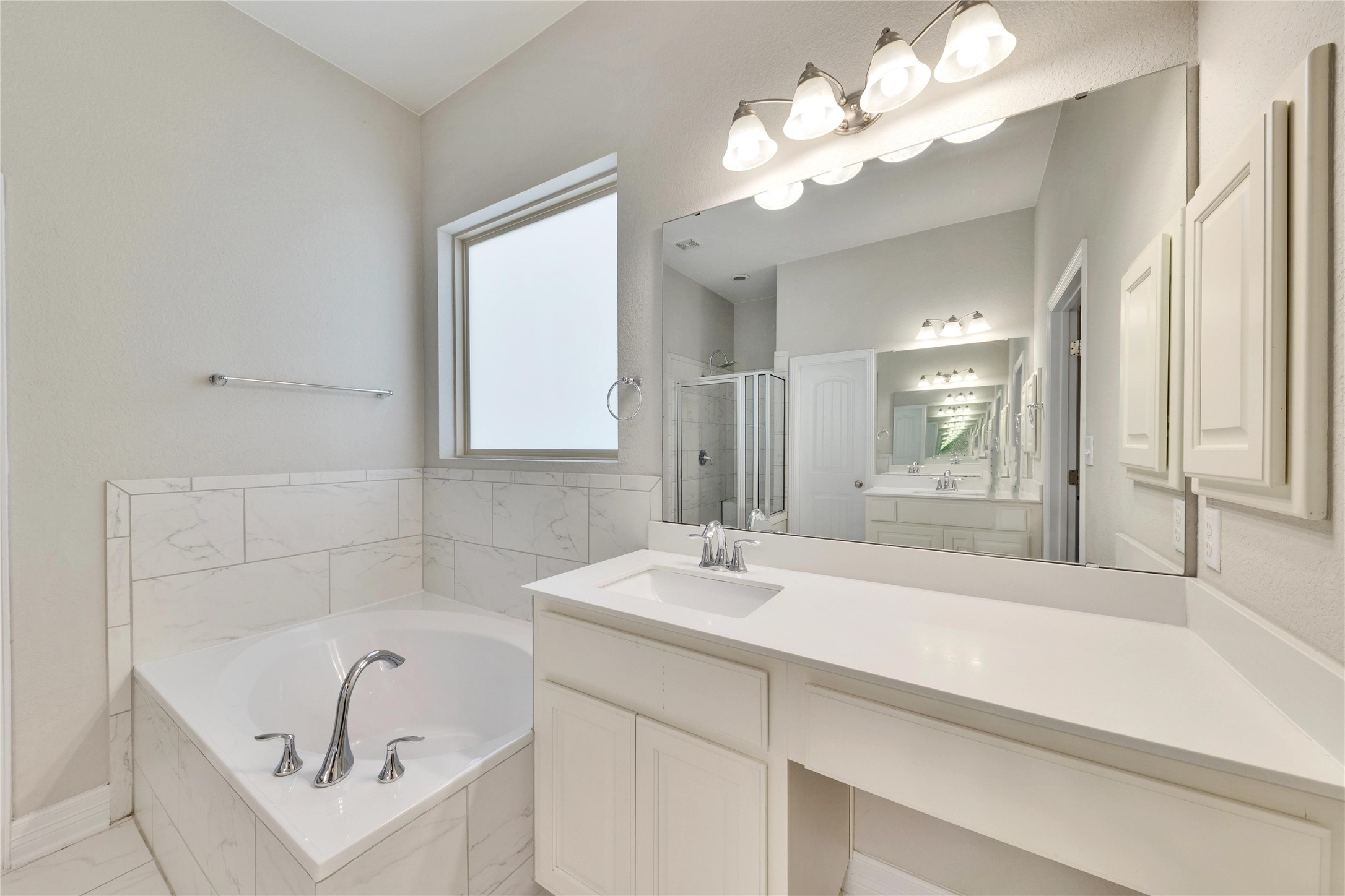 5213 Buchanan Draw Road Austin, TX 78738 - Photo 14 of 33 a bathroom with a tub a sink and a mirror