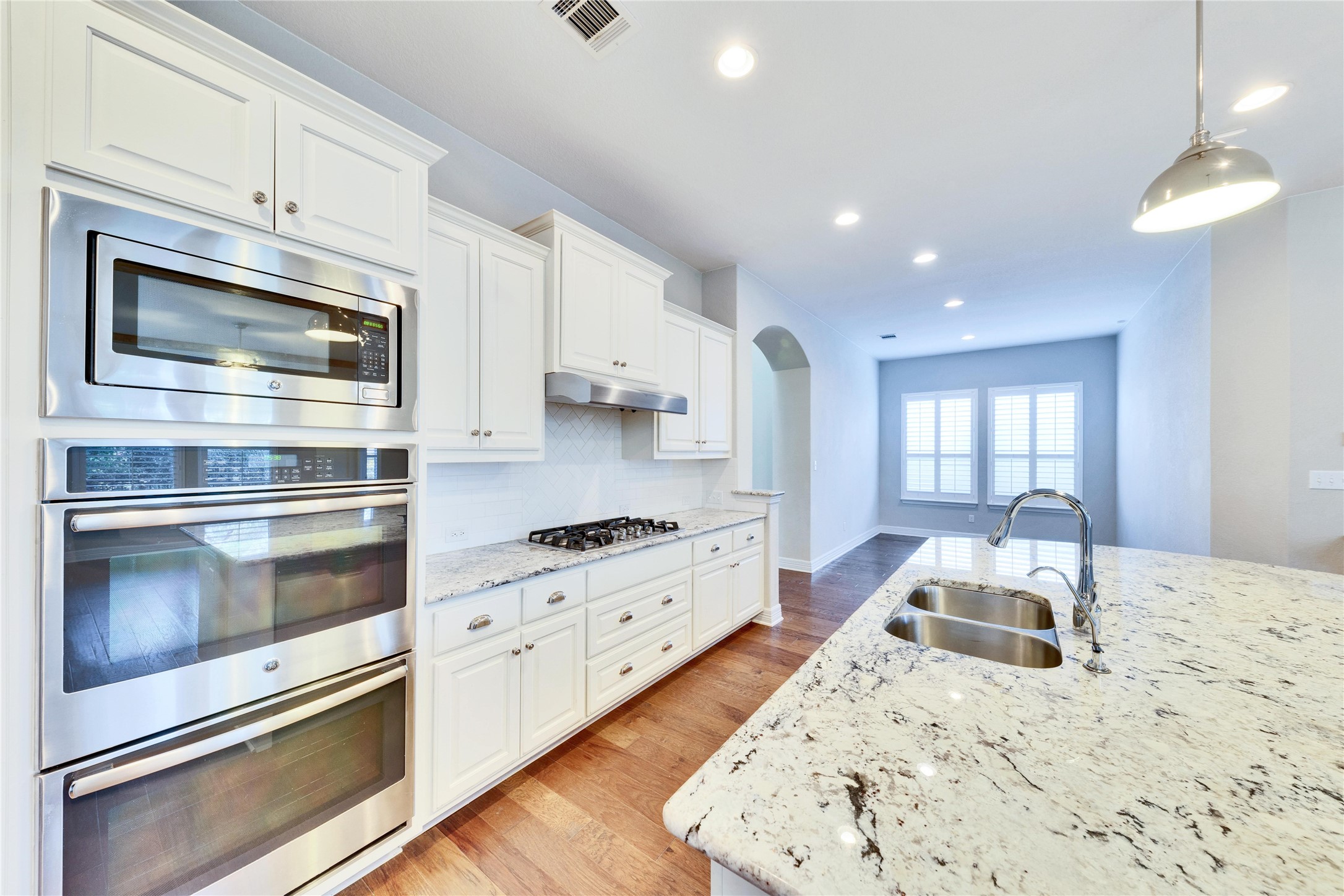 5213 Buchanan Draw Road Austin, TX 78738 - Photo 6 of 33 a kitchen with granite countertop white cabinets and stainless steel appliances
