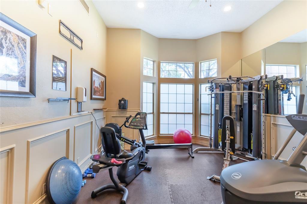 12680 Hillcrest Road, Unit 4101 Dallas, TX 75230 - Photo 36 of 37 Dedicated fitness area featuring extensive natural light from a bay window, wainscoting details, and mirrored wall accents