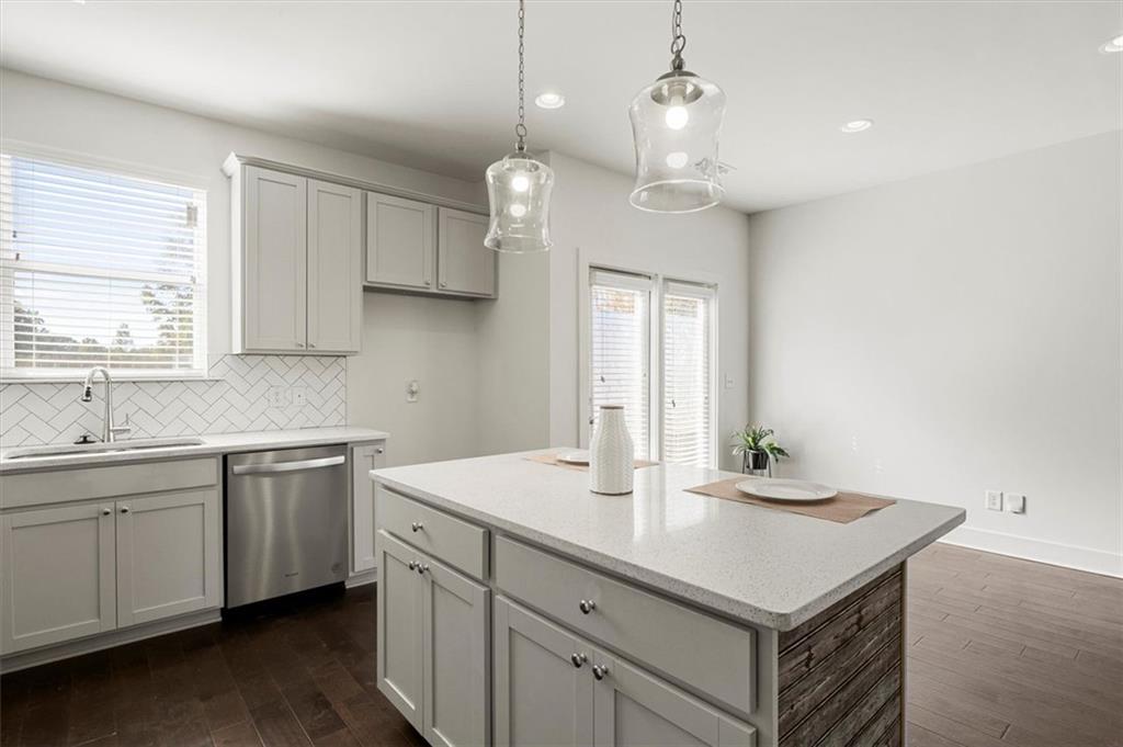 6347 Princeton Ridge Drive Lithonia, GA 30058 - Photo 11 of 28 a kitchen with a sink dishwasher and white cabinets with wooden floor