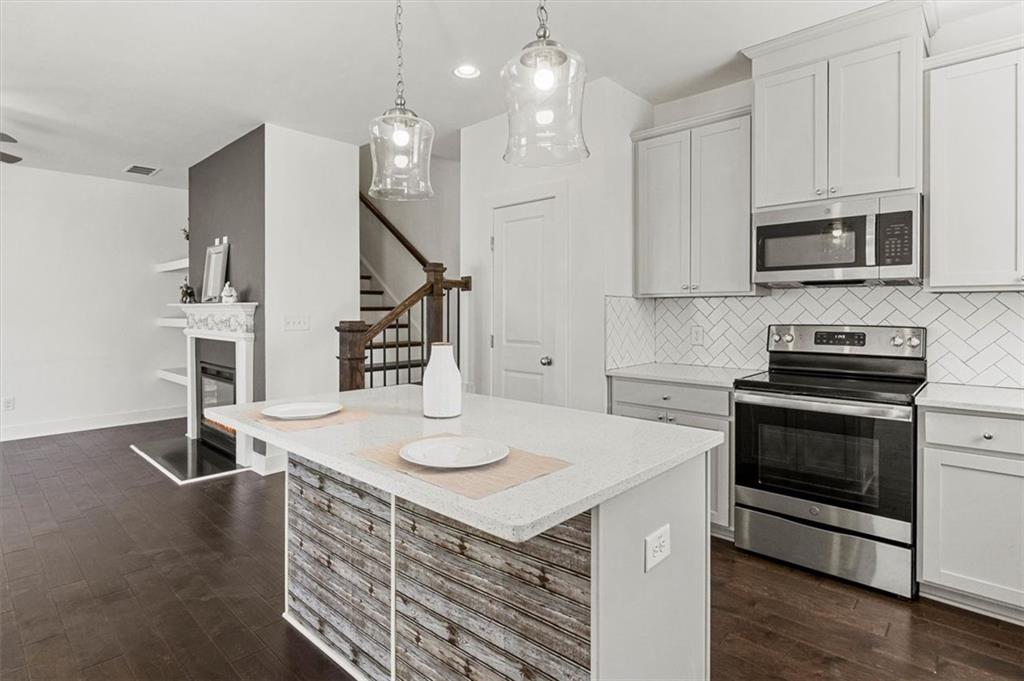 6347 Princeton Ridge Drive Lithonia, GA 30058 - Photo 13 of 28 a kitchen with stainless steel appliances granite countertop a sink a stove and a wooden floors