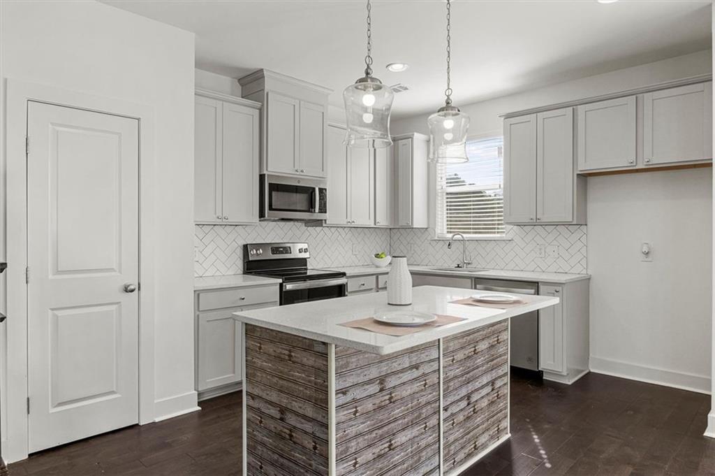 6347 Princeton Ridge Drive Lithonia, GA 30058 - Photo 10 of 28 a kitchen with kitchen island granite countertop a sink stove and microwave