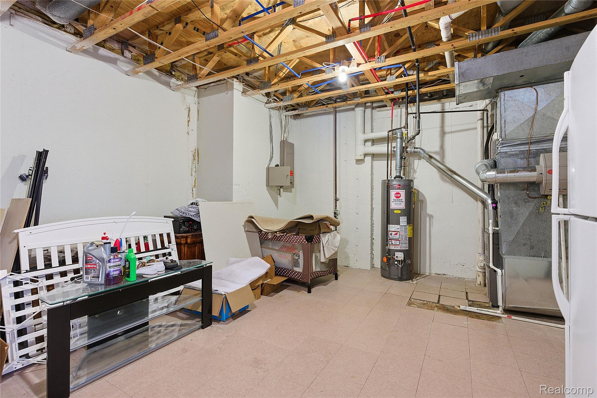 7154 Westchester Road West Bloomfield, MI 48322 - Photo 29 of 38 Unfinished below grade area with light floors, freestanding refrigerator, water heater, and heating unit
