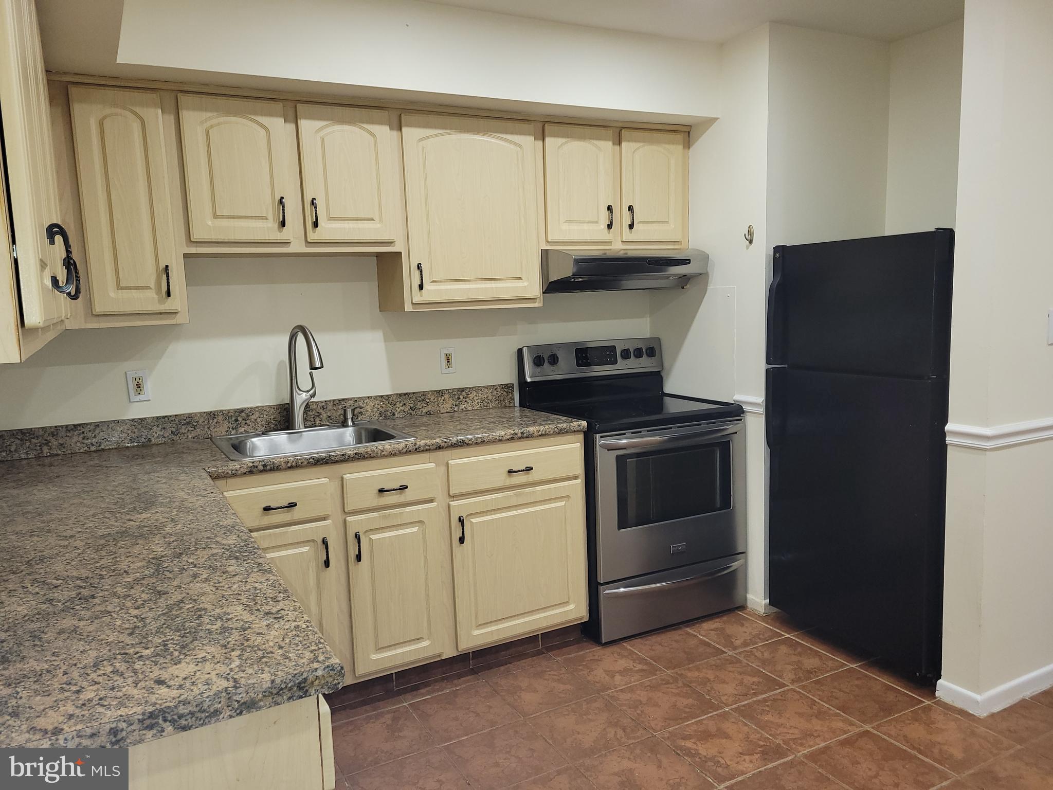 Avon Drive, Unit J East Windsor, NJ 08520 - Photo 11 of 15 a kitchen with granite countertop white cabinets and stainless steel appliances