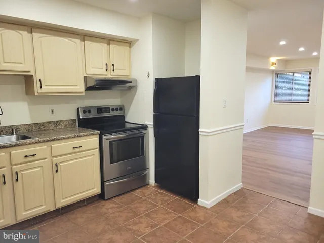 a kitchen with white cabinets and refrigerator