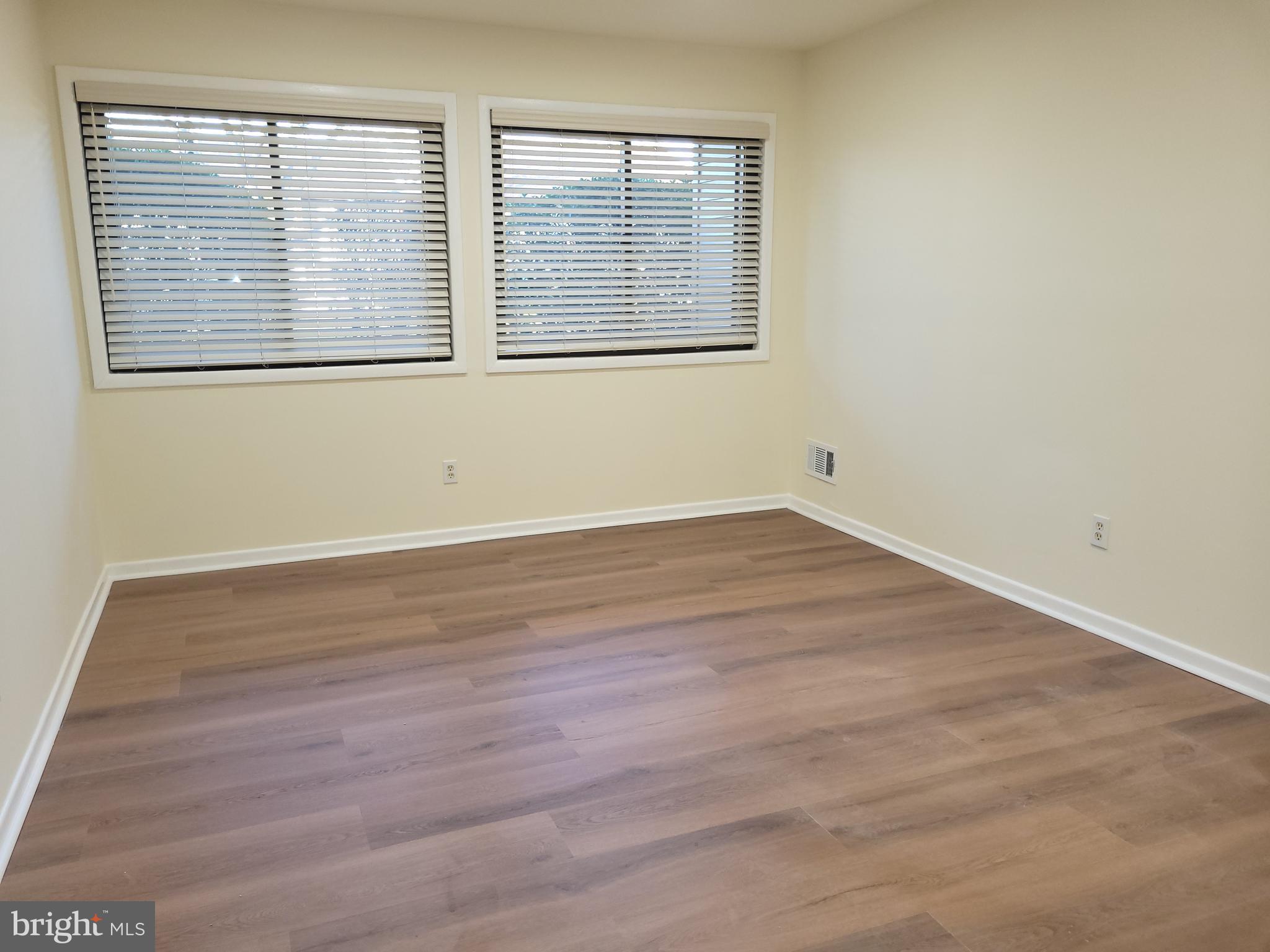 Avon Drive, Unit J East Windsor, NJ 08520 - Photo 7 of 15 an empty room with wooden floor and windows