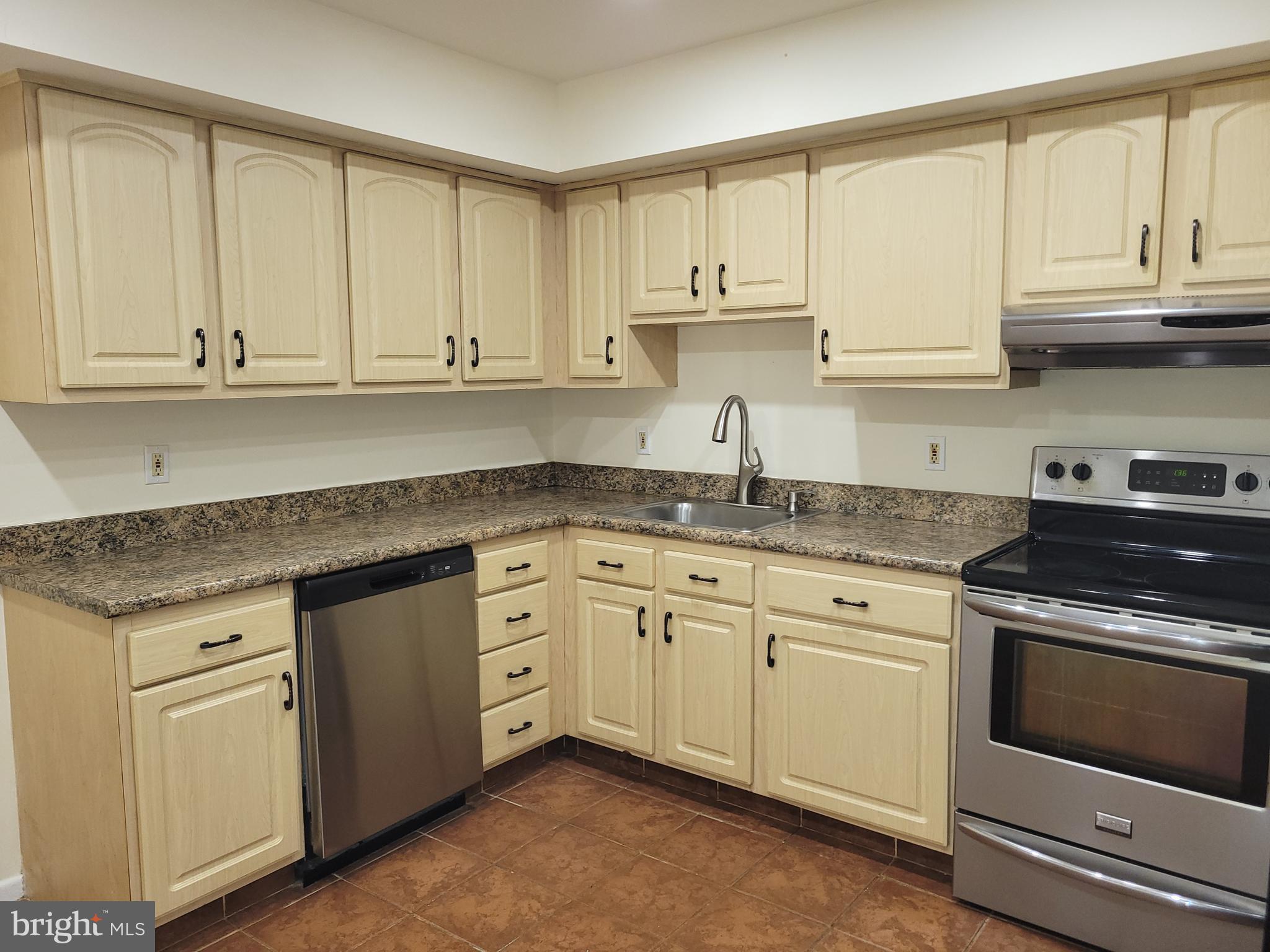 Avon Drive, Unit J East Windsor, NJ 08520 - Photo 9 of 15 a kitchen with granite countertop white cabinets and a stove