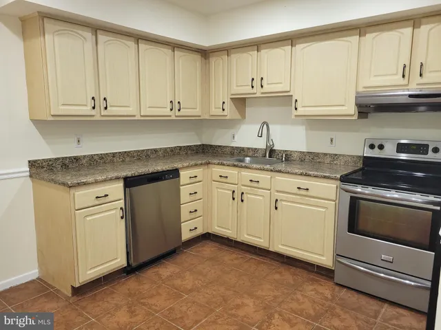 a kitchen with stainless steel appliances granite countertop a sink a stove and cabinets
