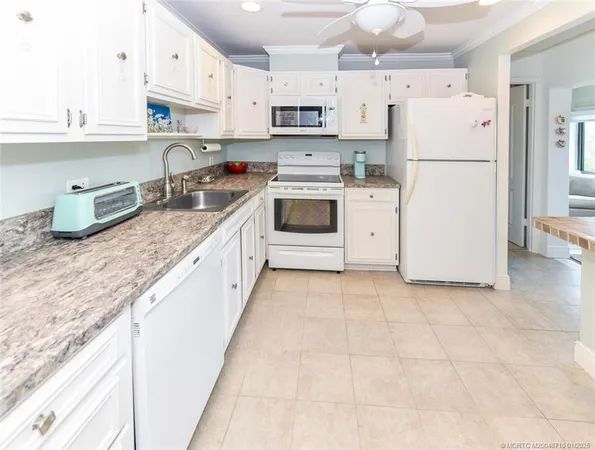 a kitchen with granite countertop cabinets appliances and wooden floor
