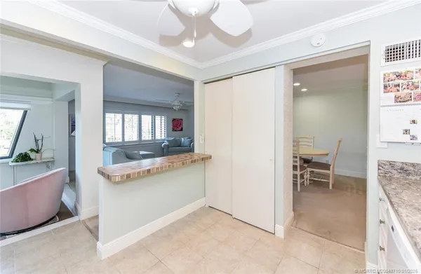 a kitchen with granite countertop a refrigerator a stove a sink and white cabinets
