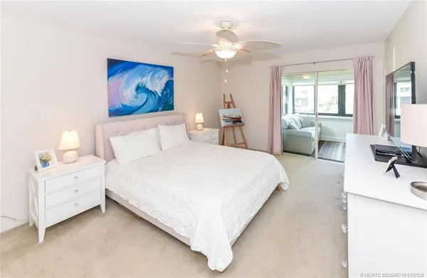 a spacious bedroom with a bed and a chandelier