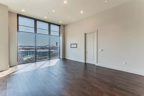 an empty room with wooden floor and sliding glass door