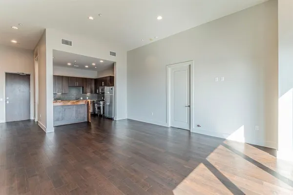 a view of a hallway with wooden floor and glass door