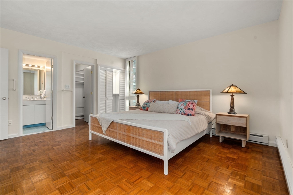 75 Grove Street, Unit 227 Wellesley, MA 02482 - Photo 17 of 29 a spacious bedroom with a bed and cabinet
