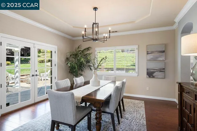 a dining room with furniture a chandelier and wooden floor
