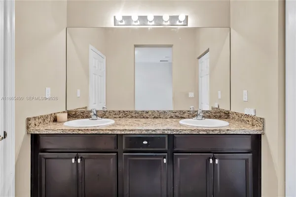 a bathroom with a granite countertop sink and a mirror