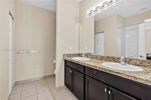 a bathroom with a granite countertop sink a large mirror and a shower