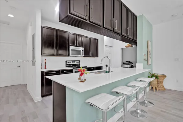 a kitchen with stainless steel appliances a sink and a refrigerator
